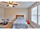 This bedroom features a neutral color scheme, ceiling fan, and window bringing in natural light at 1080 Gaithers Rd, Mansfield, GA 30055