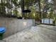 View of the backyard with concrete patio, retaining wall, shed, and seating area at 142 Kylee Ct, Villa Rica, GA 30180