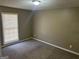 This neutral bedroom has cozy carpet, a window with blinds, and a simple light fixture at 6625 Paula Ct, Lithonia, GA 30038