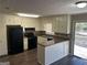 Cozy kitchen with white cabinets, black appliances, and access to an outdoor deck at 6625 Paula Ct, Lithonia, GA 30038
