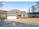 Gray home with an attached garage, stone accents, and a well-manicured lawn near a lake at 1278 Heritage Dr, Villa Rica, GA 30180