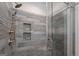 Modern bathroom shower featuring gray stone tile, mosaic accents and a built-in shelf for storage at 1278 Heritage Dr, Villa Rica, GA 30180