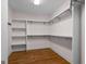 Spacious walk-in closet with custom shelving, hanging racks, and hardwood flooring at 1278 Heritage Dr, Villa Rica, GA 30180