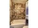 Tiled bathroom showcasing the shower/tub combination with stone-look tiles and modern fixtures at 110 Paces Dr, Fayetteville, GA 30215