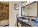 Elegant bathroom featuring dark granite countertops, modern fixtures, and a tiled shower/tub combo at 110 Paces Dr, Fayetteville, GA 30215