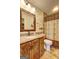 Traditional bathroom with a decorative shower curtain, granite countertops, and a wood vanity with a framed mirror at 110 Paces Dr, Fayetteville, GA 30215
