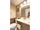Traditional bathroom features a dark vanity, framed mirror, and tiled walls and flooring at 110 Paces Dr, Fayetteville, GA 30215