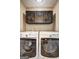 A functional laundry room features a modern washer and dryer set with overhead storage cabinets at 110 Paces Dr, Fayetteville, GA 30215