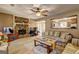 Comfortable living room featuring a stone fireplace, ceiling fan, and views into the kitchen at 110 Paces Dr, Fayetteville, GA 30215