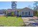 Quaint single-story house featuring a fenced yard, a well-lit walkway, and mature trees offering ample shade at 342 Lakeshore Dr, Stockbridge, GA 30281