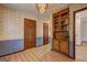 Hallway featuring wallpaper, wood-look flooring, and built in cabinet at 342 Lakeshore Dr, Stockbridge, GA 30281