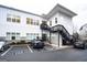Modern white building with black stairs, complemented by ample parking spaces and manicured landscaping at 170 Fowler St # 200, Woodstock, GA 30188