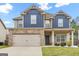 Charming two-story home with a brick and blue exterior, attached garage, and well-maintained lawn at 312 Maddi Grace Ct, Locust Grove, GA 30248
