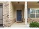 Inviting front door with sidelight, brick accents, and well-maintained landscaping at 312 Maddi Grace Ct, Locust Grove, GA 30248