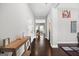 Bright hallway with hardwood floors, leading to dining area, with art on the walls at 312 Maddi Grace Ct, Locust Grove, GA 30248