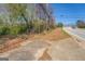 Street view showcasing a road with an empty lot and adjacent trees at 1849 Panola Rd, Stone Mountain, GA 30088