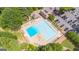 Aerial view of a large community pool with lounge chairs, a clubhouse, parking, and lush green surroundings at 7085 Wakehurst Pl, Cumming, GA 30040