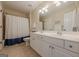 This full bathroom is complete with a double vanity, a large mirror, and a shower and tub at 7085 Wakehurst Pl, Cumming, GA 30040