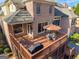 Aerial view of a deck with a dining set and grill, perfect for outdoor entertaining with a screened porch underneath at 7085 Wakehurst Pl, Cumming, GA 30040