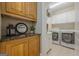 Convenient laundry room features granite counters, white cabinetry and modern appliances at 7085 Wakehurst Pl, Cumming, GA 30040