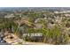 This aerial showcases the expansive +/- 6.09 acres lot with mature trees and waterfront views at 897 Winding Trl, Lawrenceville, GA 30046