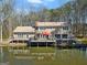 Aerial view of a lakeside house featuring a deck with outdoor furniture and serene water views at 897 Winding Trl, Lawrenceville, GA 30046