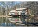 Rear view of a home on a lake with a deck and a patio providing tranquil outdoor space at 897 Winding Trl, Lawrenceville, GA 30046