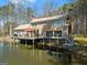 Scenic view of the back of a home by the lake with a spacious deck with multiple access points at 897 Winding Trl, Lawrenceville, GA 30046