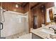 Primary bath with stand up shower with glass door, wood paneled walls and granite vanity at 897 Winding Trl, Lawrenceville, GA 30046