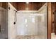 Primary bath with stand up shower with glass door, wood paneled walls and granite floors at 897 Winding Trl, Lawrenceville, GA 30046