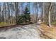 Long gravel driveway leading to the home, surrounded by mature trees and natural landscaping at 897 Winding Trl, Lawrenceville, GA 30046