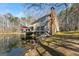 Exterior view of the home showcasing the back deck overlooking the lake and mature landscaping at 897 Winding Trl, Lawrenceville, GA 30046