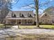 Charming home featuring a welcoming front porch, dormer windows, and gravel driveway at 897 Winding Trl, Lawrenceville, GA 30046