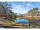 Scenic view of the lake with a rustic boathouse, mature trees, and tranquil water at 897 Winding Trl, Lawrenceville, GA 30046