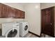 Bright laundry room featuring a washer and dryer with dark wood cabinets at 897 Winding Trl, Lawrenceville, GA 30046