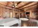 A rustic main bedroom features wood paneled walls, beamed ceilings, fireplace, and hardwood floors at 897 Winding Trl, Lawrenceville, GA 30046