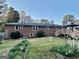 Back of a brick home with a well-maintained yard, accented with a gazebo and flower beds at 398 Lockridge Ln, Lawrenceville, GA 30046