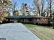 Charming brick home featuring an attached carport and a well-maintained front yard with mature trees at 398 Lockridge Ln, Lawrenceville, GA 30046