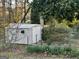 View of the backyard shed surrounded by blooming flowers and greenery at 398 Lockridge Ln, Lawrenceville, GA 30046