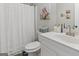 Well-lit bathroom featuring a white shower curtain, decorative artwork, and coordinating vanity at 830 Turner Rd, Mcdonough, GA 30252