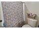 Cozy bathroom with floral shower curtain and a floral arrangement at 830 Turner Rd, Mcdonough, GA 30252