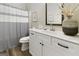 Bright bathroom featuring a modern vanity with white countertop and blue striped shower curtain at 830 Turner Rd, Mcdonough, GA 30252