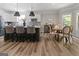 Open concept kitchen and dining featuring a kitchen island, barstools, white cabinets and tile backsplash at 830 Turner Rd, Mcdonough, GA 30252