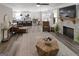 Open-concept living room with hardwood floors, a stone fireplace, and a seamless connection to the kitchen and dining area at 830 Turner Rd, Mcdonough, GA 30252