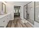 Elegant main bathroom featuring a frameless shower, double vanity with sleek white cabinetry, and tiled floors at 830 Turner Rd, Mcdonough, GA 30252
