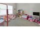 Spacious playroom with ample natural light, featuring a dollhouse and pink toy furniture at 830 Turner Rd, Mcdonough, GA 30252