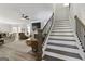View from staircase into open concept living area with fireplace, sofas, ceiling fan, and eat-in kitchen at 830 Turner Rd, Mcdonough, GA 30252