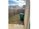 Enclosed backyard with a wooden fence, green grass, and a large green trash bin at 2478 Oakleaf Rdg, Lithonia, GA 30058
