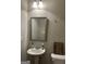 Small, well-lit bathroom with a pedestal sink and framed mirror, adjacent to the toilet at 2478 Oakleaf Rdg, Lithonia, GA 30058