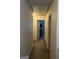 Narrow hallway featuring neutral walls and carpeting, connecting to other rooms in the home at 2478 Oakleaf Rdg, Lithonia, GA 30058